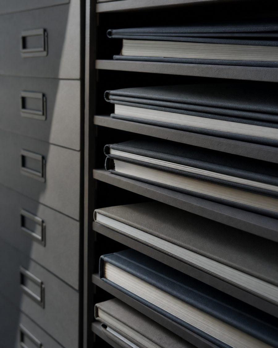 A shelf of neatly stacked bound reports in raking side light